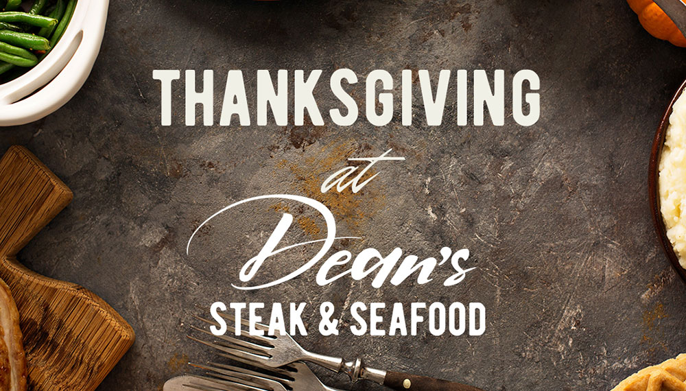 A holiday meal on a table with the words Thanksgiving at Dean’s Steak and Seafood in the center