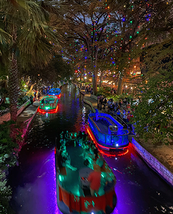 A decorated boat, floating down the river at the San Antonio Riverwalk